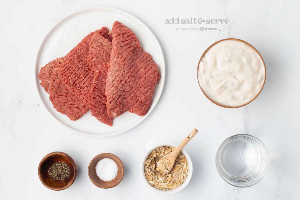 Ingredients for crock pot cube steak and mushroom soup: cube steak, Lipton soup mix, condensed cream of mushroom soup, salt, pepper, and water.