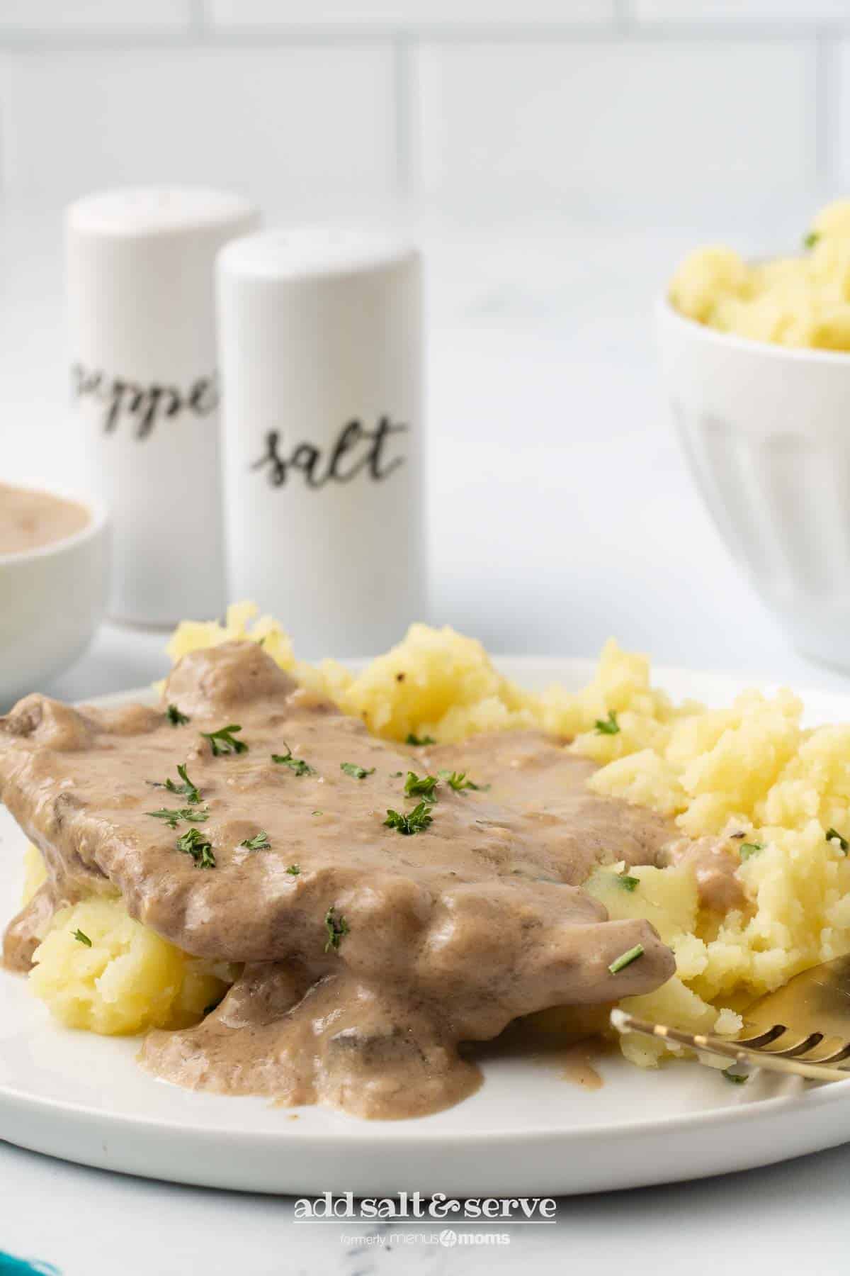 Cube steak with mushroom soup gravy served over mashed potatoes.