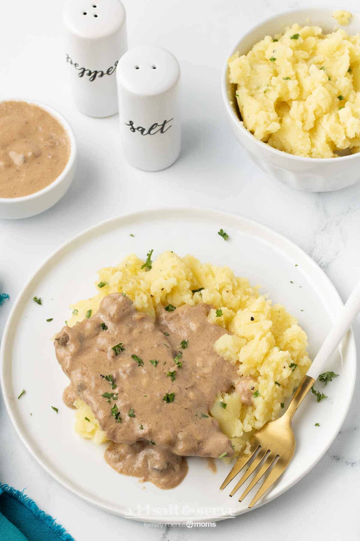 Cube steak with mushroom soup gravy served over mashed potatoes.