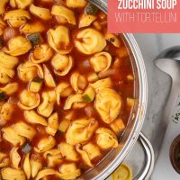 Pot of cooked tomato zucchini soup with tortellini.