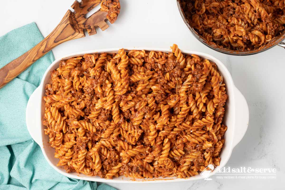 Spiral pasta bake in a white casserole dish before baking.