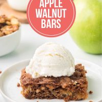 An Apple Walnut Bar topped with vanilla ice cream on a white plate with a green apple and a bowl of walnuts in the background.