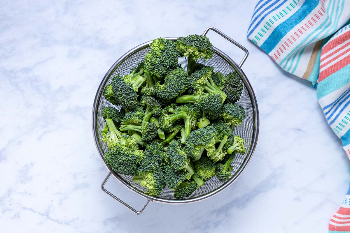 A strainer full of broccoli florets