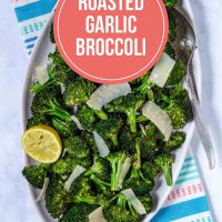 A serving bowl full of broccoli florets, garnished with a lemon half, with text Roasted Garlic Broccoli
