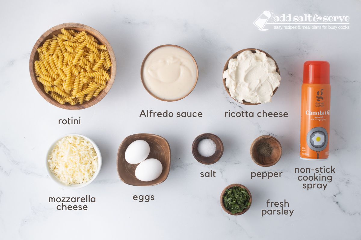 Ingredients for Rotini Pasta Bake: rotini, Alfredo sauce, ricotta cheese, mozzarella cheese, eggs, salt, pepper, fresh parsley, and non-stick cooking spray.