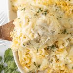 Rotini Pasta Bake in a baking dish with a spoonful scooped out on a wooden spoon.