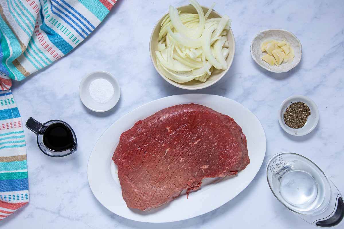 Ingredients for corck pot London Broil with au jus: London Broil roast, water, salt, pepper, onions, garlic, and soy sauce.