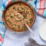 French Onion Rice garnished with parsley in a casserole dish with a serving spoon.