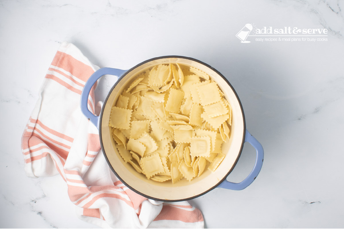 Dutch oven of cheese ravioli in water.