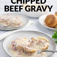 Plate of creamy chipped beef gravy over two biscuit halves with a forkful held above the plate on a counter next to another plate of biscuits and gravy, a bowl of the gravy, and a plate of biscuits with text Creamy Chipped Beef Gravy.