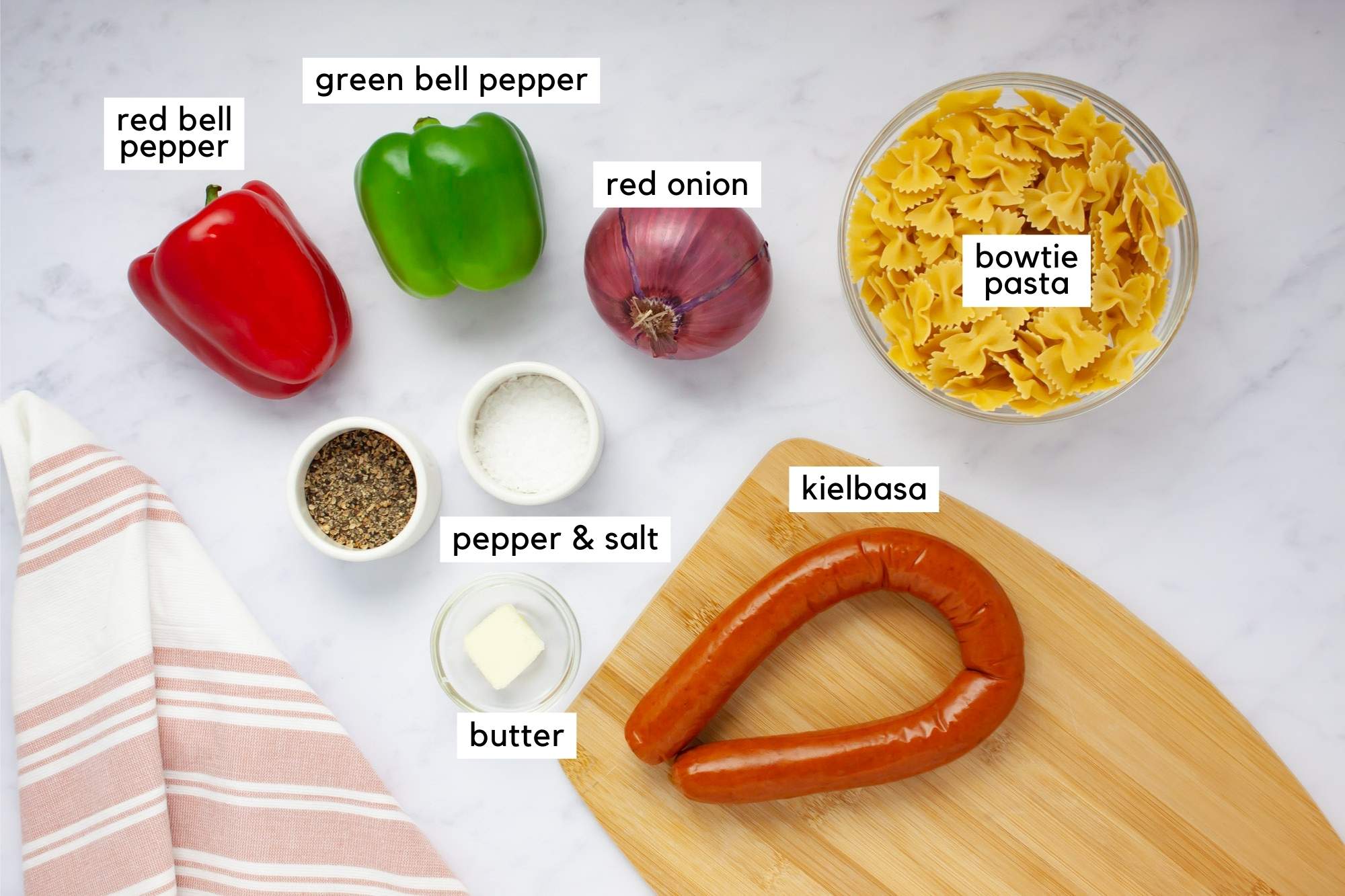 Ingredients for Kielbasa Pepper Pasta: bowtie pasta, kielbasa, red pepper, green pepper, red onion, butter, salt, and pepper.