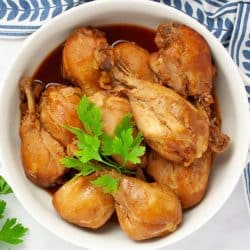 Cooked chicken legs in a serving dish garnished with parsley.