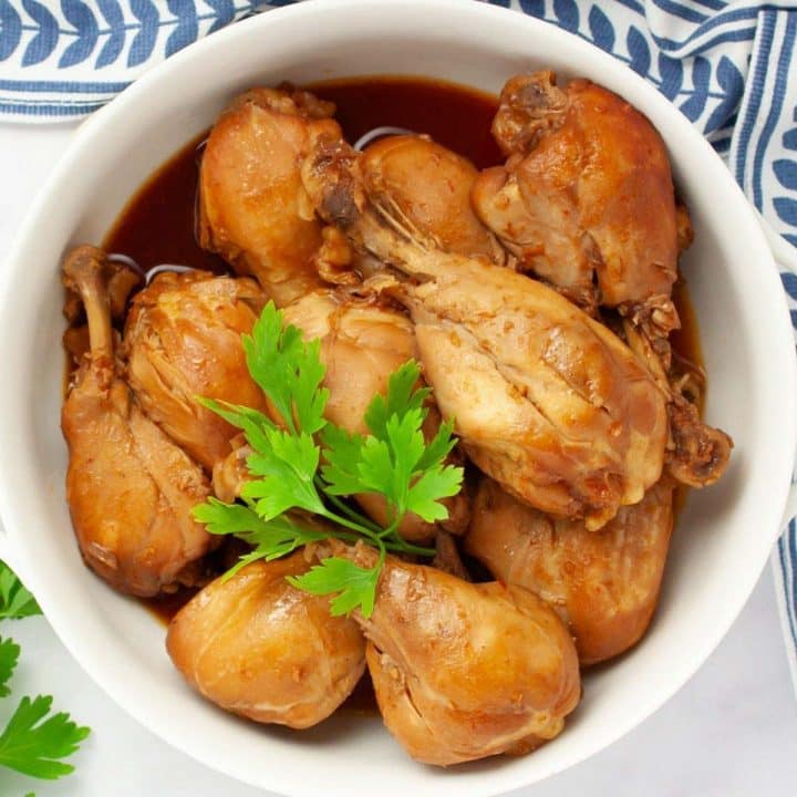 Cooked chicken legs in a serving dish garnished with parsley.