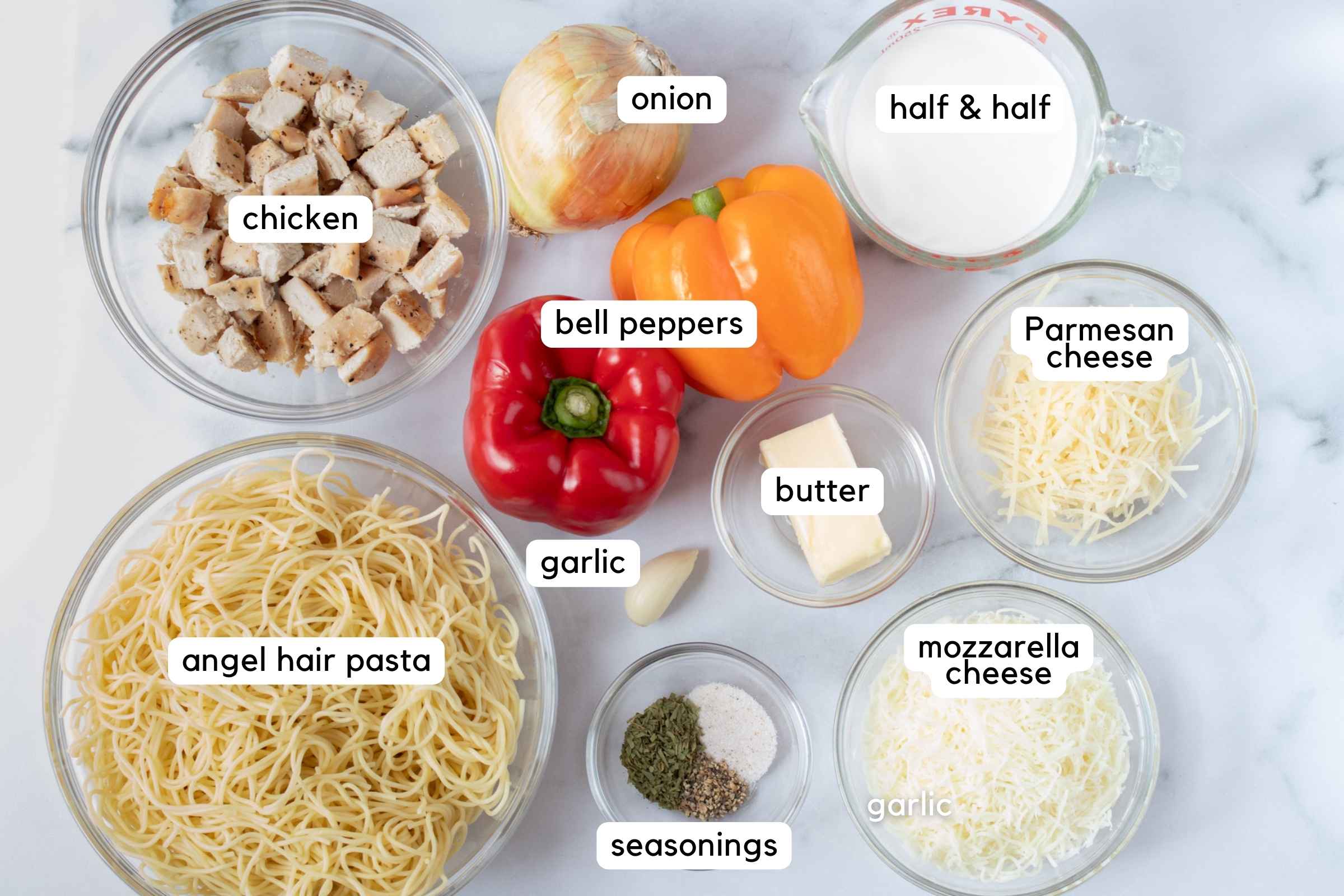 Ingredients: cooked chicken, onion, red bell pepper, yellow bell pepper, half and half, butter, garlic, shredded Parmesan cheese. shredded mozzarella cheese, cooked angel hair pasta, and small bowl with tarragon, pepper, and salt.