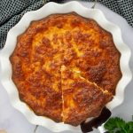 Overhead view of a slice of crustless quiche being lifted out of a pie plate.