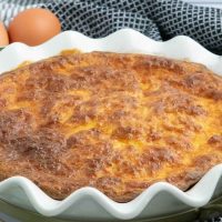 Quiche in a pie plate with text crustless quiche with cottage cheese; freezer-friendly recipe.