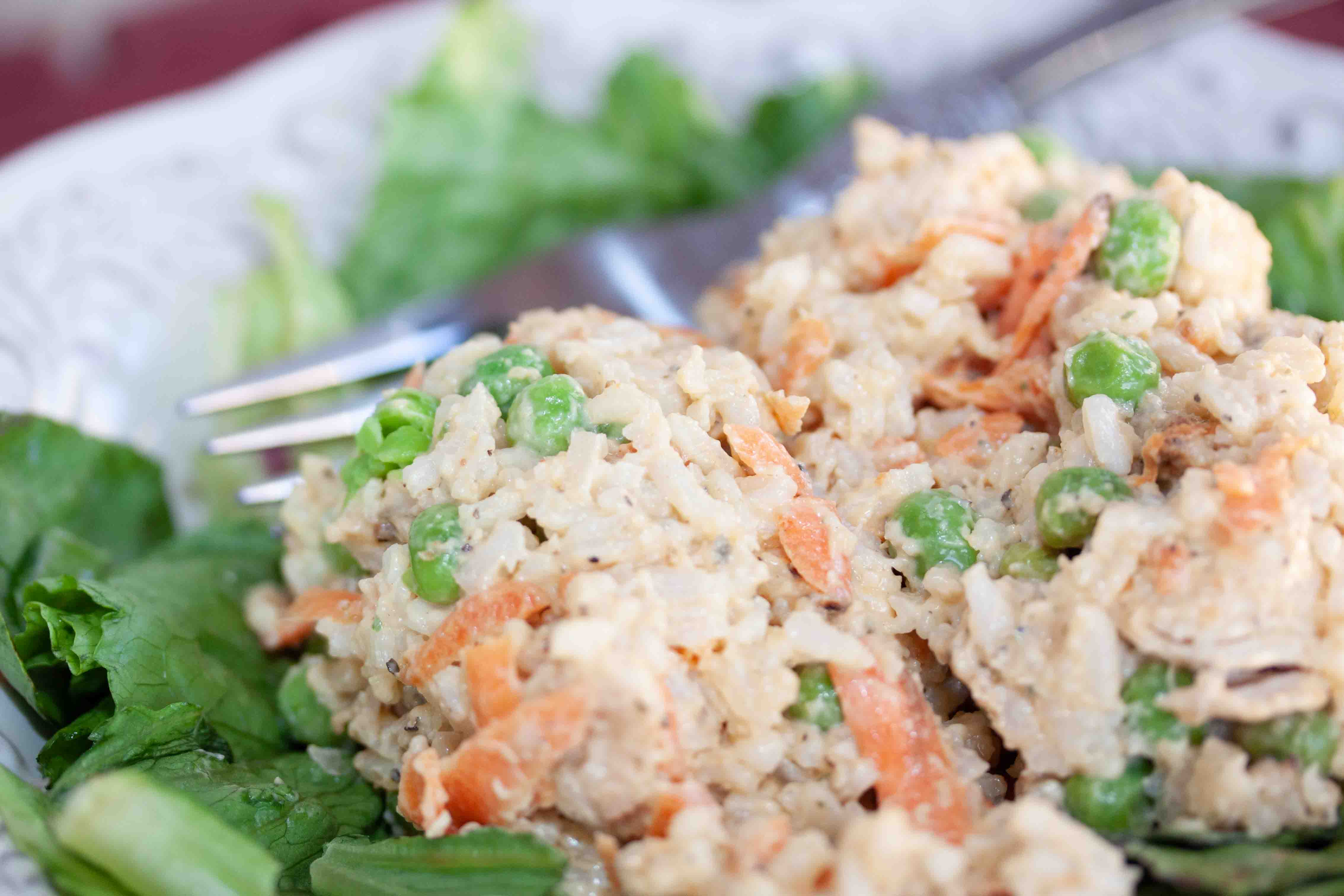 veggie-rice-salad-with-chicken-insta-min Cold rice salad with chicken and peas on a bed of lettuce.