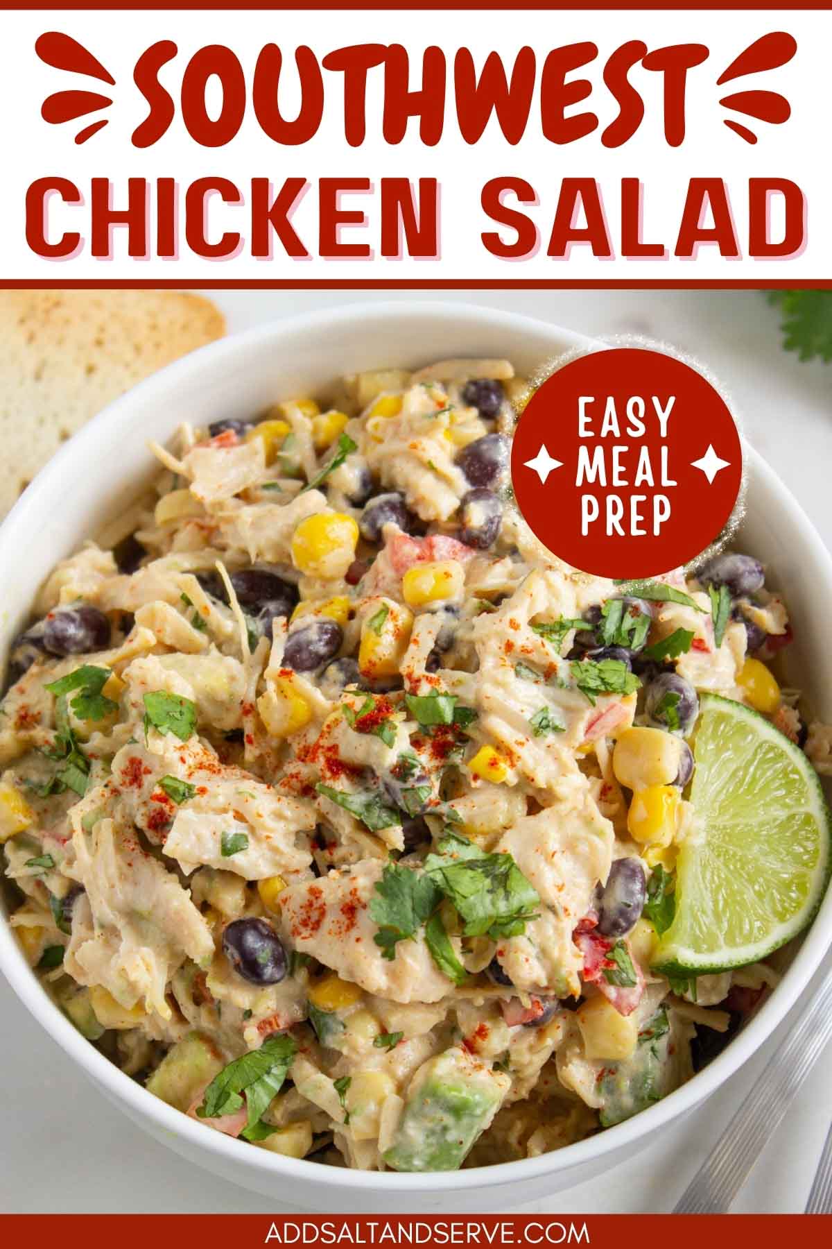 Bowl of chicken salad with corn, black beans, avocado, and red bell pepper in a creamy dressing garnished with a lime wedge and sprinkled with paprika with text Southwest Chicken Salad - easy meal prep.