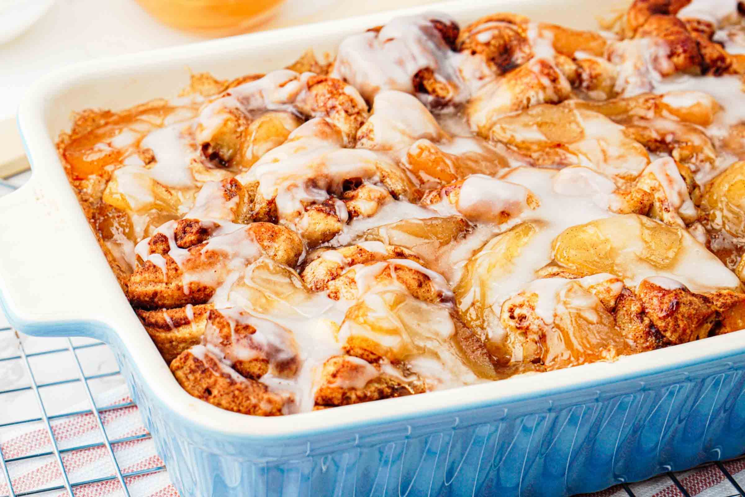 Apple cinnamon roll bake in pan with glaze on top.