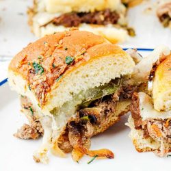 Philly cheesesteak sliders on a plate.
