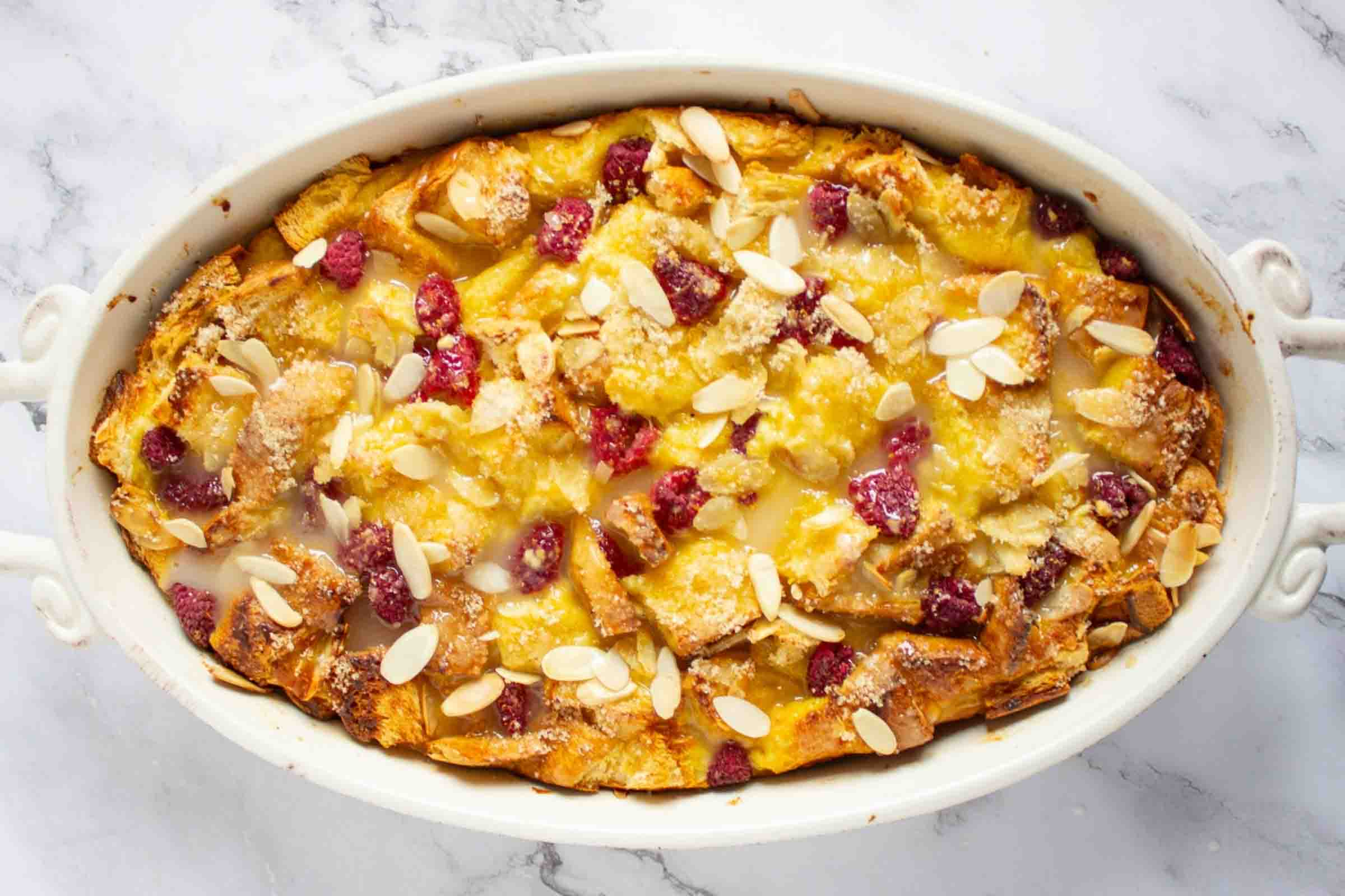 French toast bake with berries and almonds in a casserole dish.