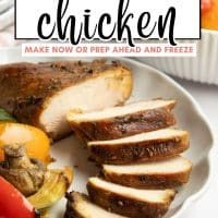 Sliced piece of grilled sesame chicken on a plate with grilled vegetables with text Grilled Sesame Chicken - make now or prep ahead and freeze; just thaw and grill.
